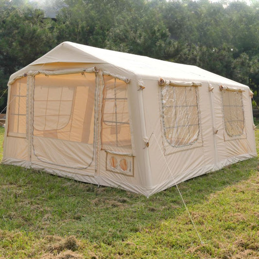 Beige camping tent with mesh windows on a grassy field
