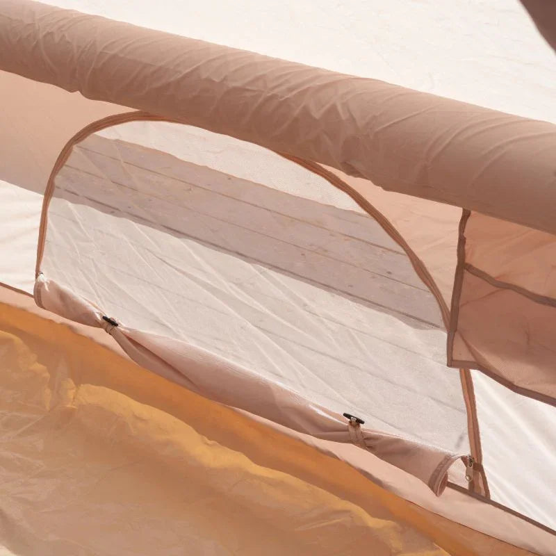 Close-up of a beige and white tent with a blurred background
