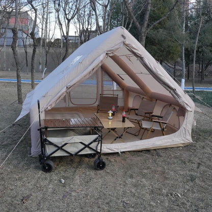 Camping tent with outdoor furniture and a cart in a park setting