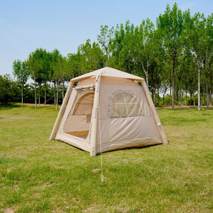 Beige camping tent on grass with trees in the background