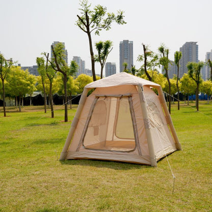 Beige camping tent on grass with trees and buildings in the background