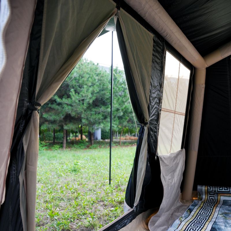 Quick setup beige ridge inflatable tent featuring hexagonal blackout and mesh porch with chairs and table in natural outdoor setting

