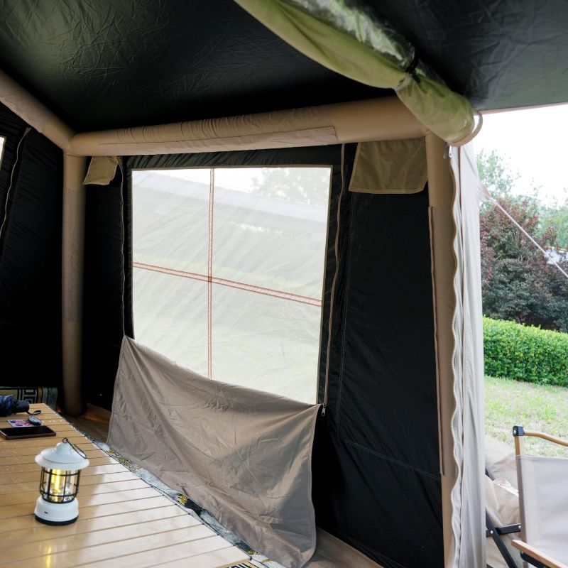 Inside a tent with a lantern on a wooden surface, showing an outdoor setting.