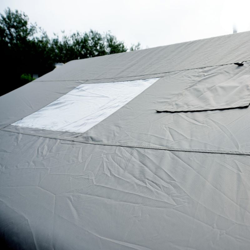 Close-up of a gray tarp with a white patch on a roof