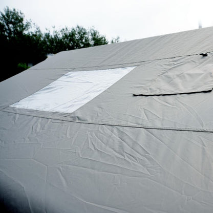 Close-up of a gray tarp with a white patch on a roof