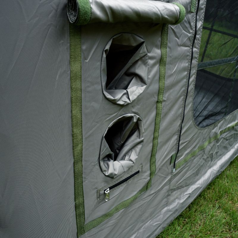 Gray camping tent with green trim on a grassy background