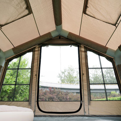 Interior of a tent with large windows showing greenery outside