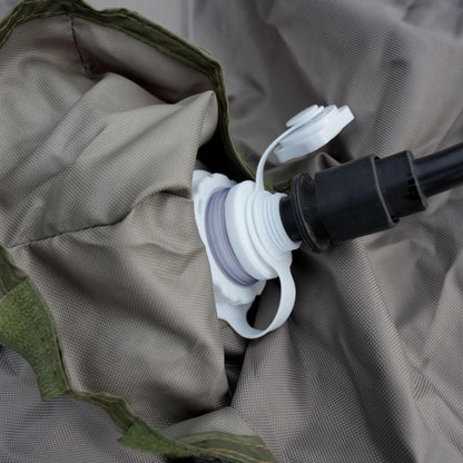 Close-up of a white hose nozzle attached to a green and gray fabric background