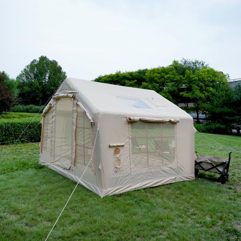 Beige canvas tent on grass with trees in the background