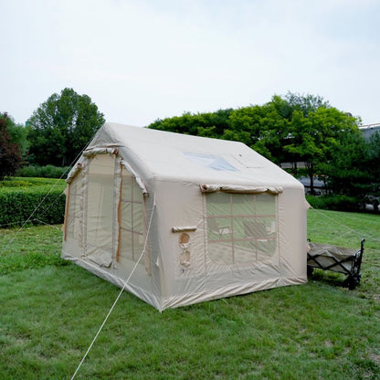 Beige canvas tent on grass with trees in the background