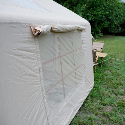 Beige tent with mesh side panel in a grassy outdoor setting