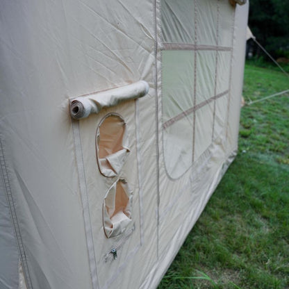 Beige tent with a damaged section on a grassy background
