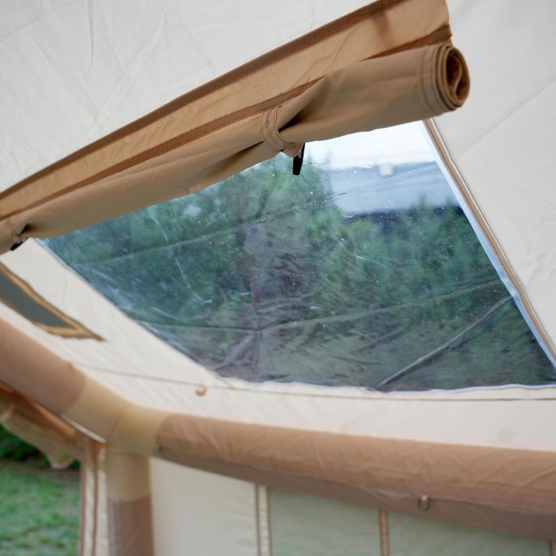 Close-up of a tent with a window showing a forest view