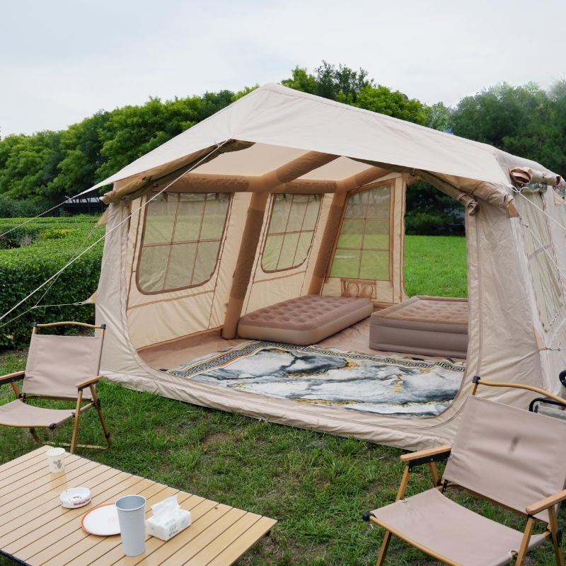Camping tent with interior furniture and outdoor setup on a grassy area.