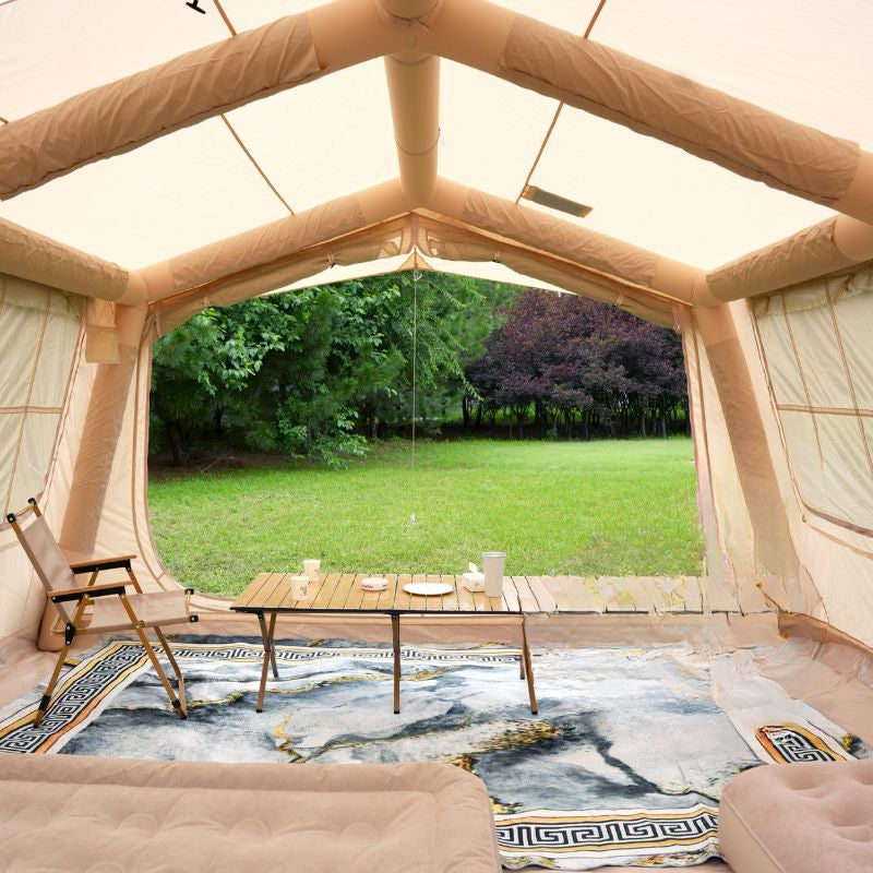 Inside a large beige tent with a table, chairs, and a view of greenery outside.