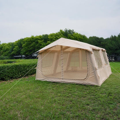 Beige camping tent on grass with trees in the background