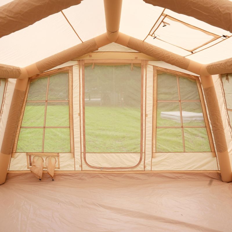 Inflatable tent interior with mesh windows and beige walls.