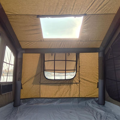 Interior of a tent with beige walls and a skylight