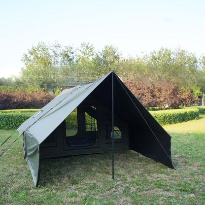 Green camping tent in a grassy area with trees in the background