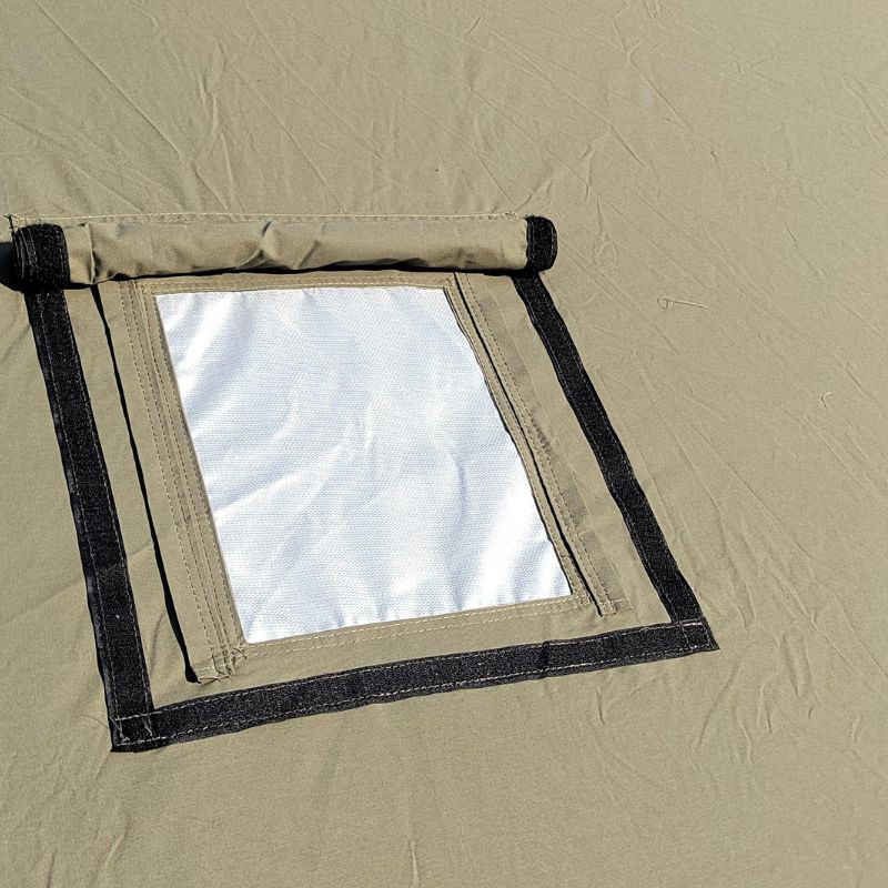 Window of a beige tent with black frame and white interior