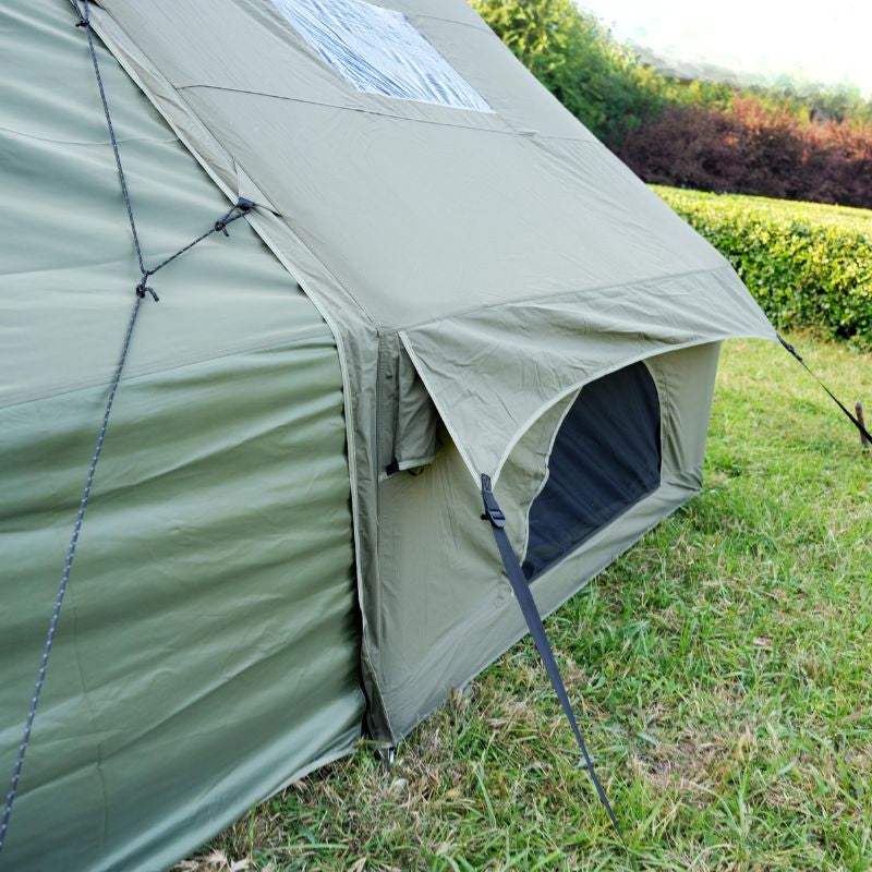 Green camping tent with solar panel on grassy area