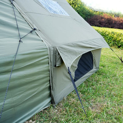 Green camping tent with solar panel on grassy area