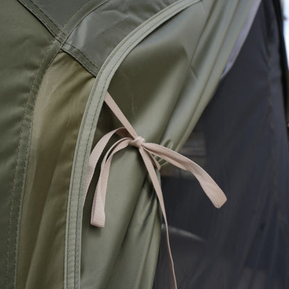 Close-up of a green fabric with a pink ribbon tied around it.