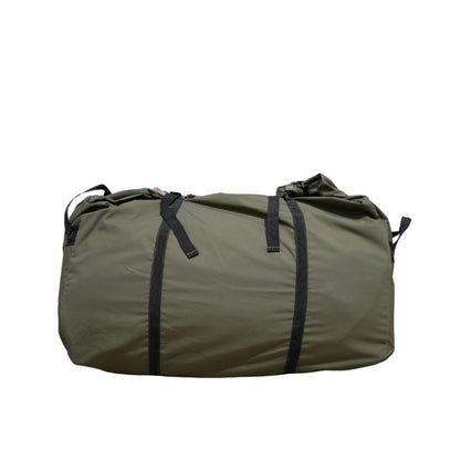 Green duffel bag with black straps on a white background
