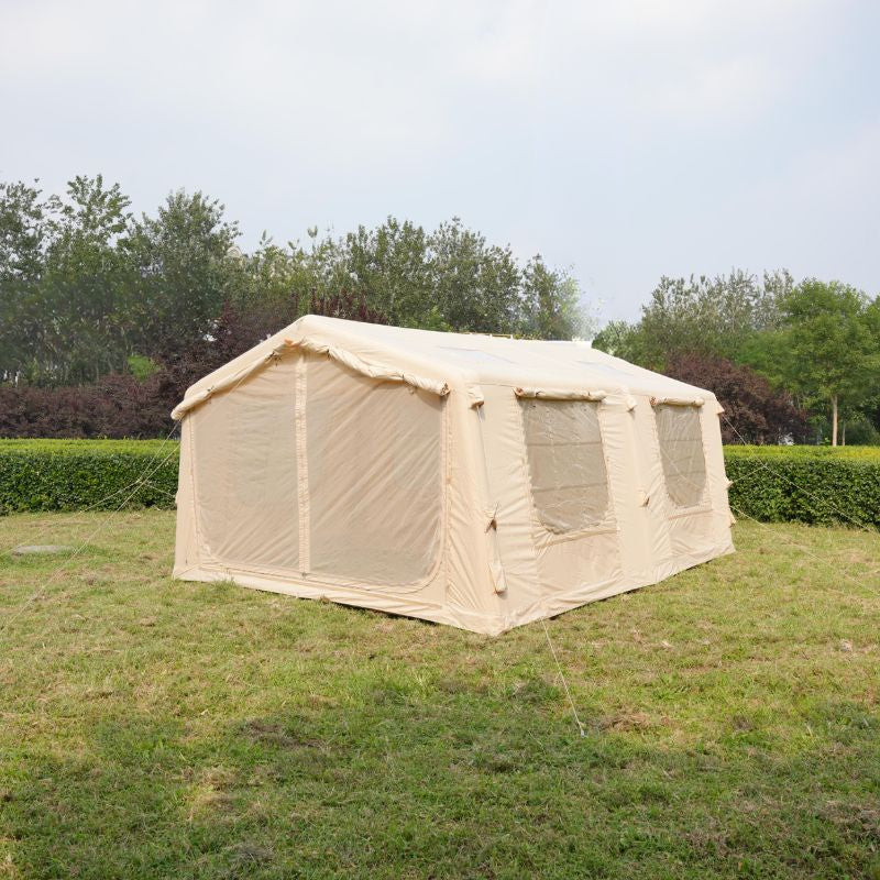 Beige tent with mesh sides on a grassy field with trees in the background