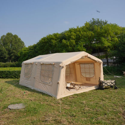 Beige camping tent with attached porch in a grassy area with trees in the background