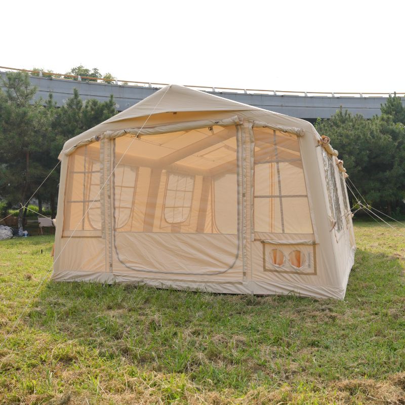 Beige camping tent with mesh sides on a grassy field