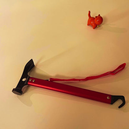 Red and black tool on a beige surface with a small red object in the background