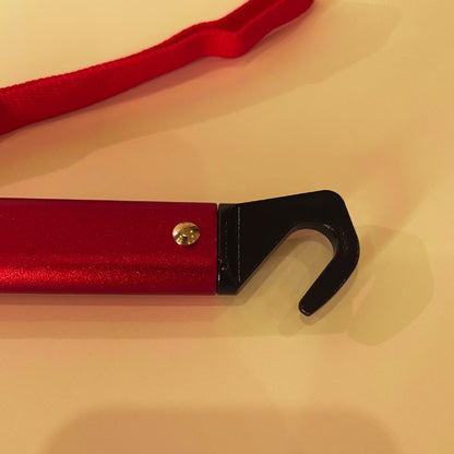 Red strap with a black metal hook on a beige background