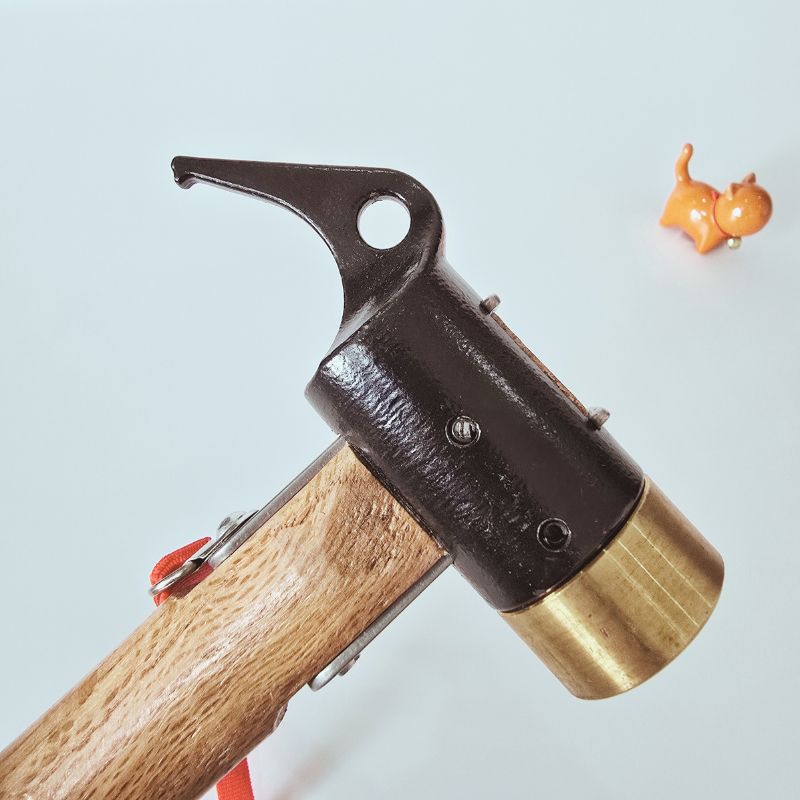 Close-up of a hammer with a wooden handle and metal head on a light blue background.