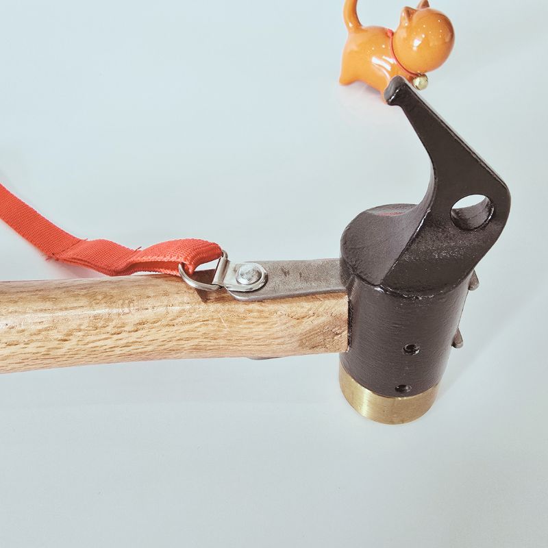 Close-up of a hunting tool with a wooden handle and metal head on a light gray background.