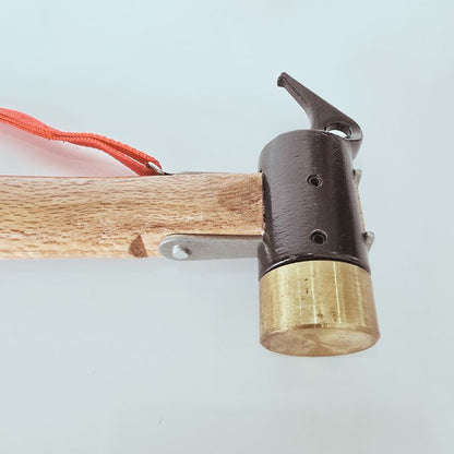 Close-up of a wooden bow with a brass nocking point on a light blue background