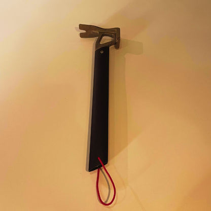 Tool with a black handle and red cord on a beige background