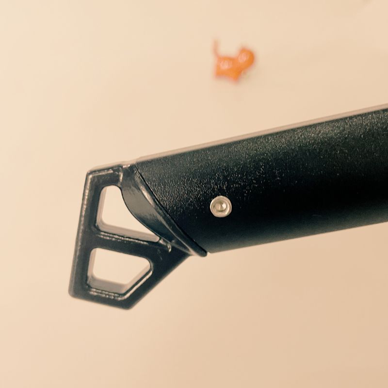 Close-up of a black metal tool on a beige background