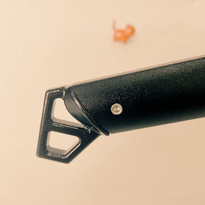 Close-up of a black metal tool on a beige background