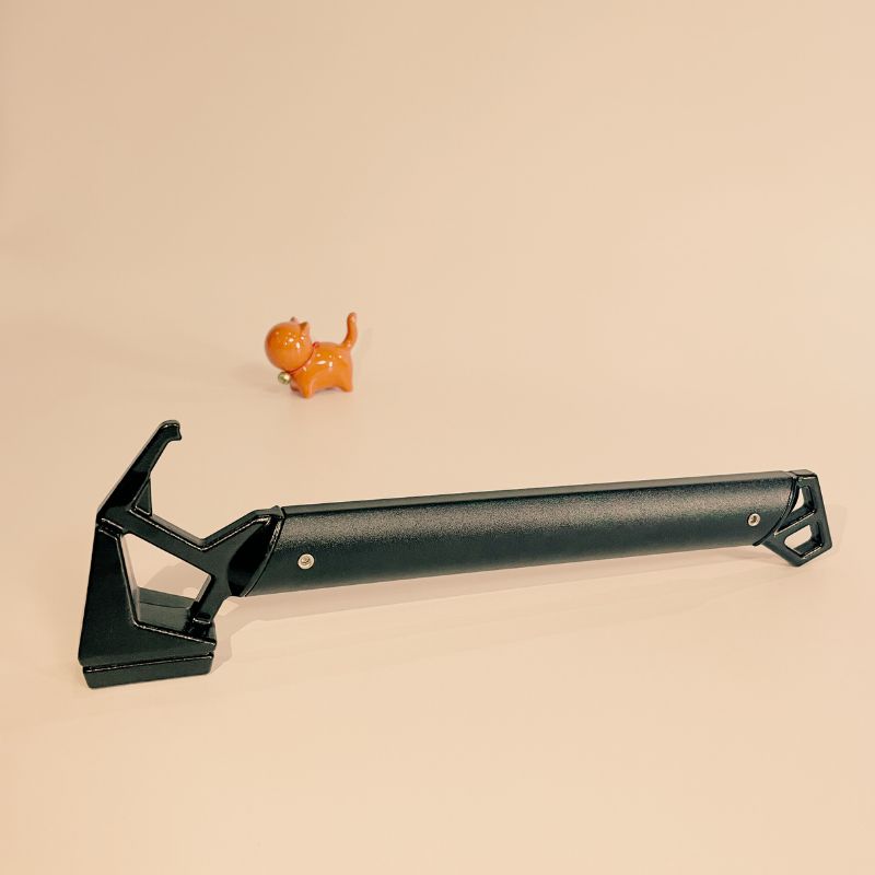 Black tool handle on a beige background with a small orange toy figure.