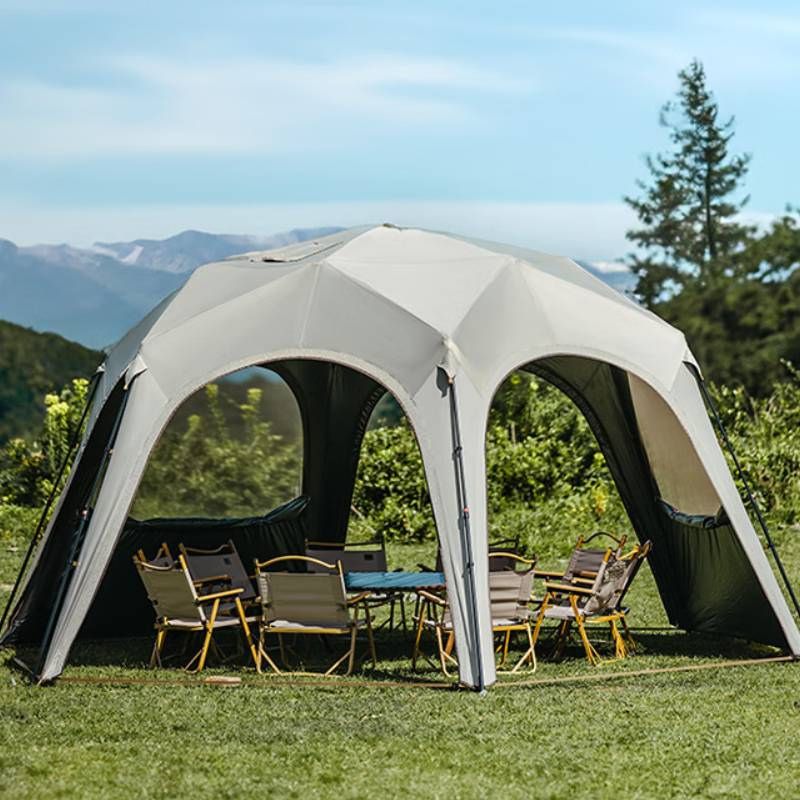 Outdoor canopy tent with chairs and a table set up in a scenic outdoor setting.