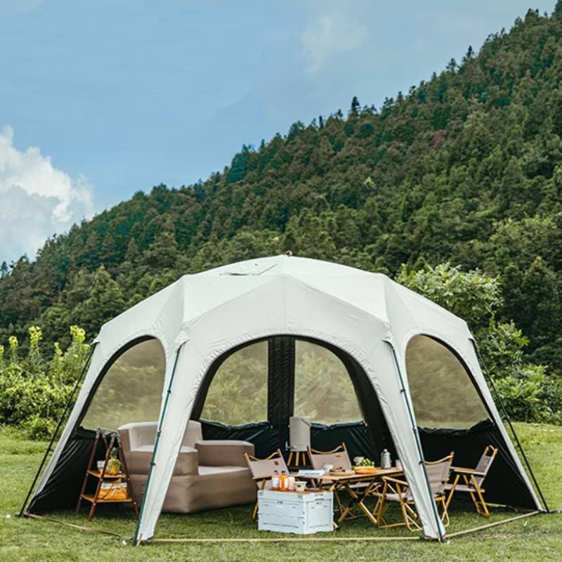 Outdoor inflatable tent with furniture set against a forest backdrop