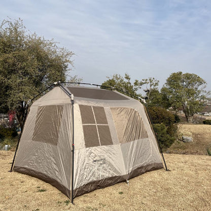Screened tent with mesh walls on a grassy area with trees in the background