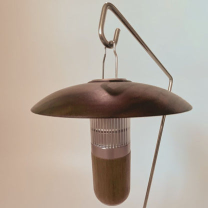 Brown hanging bird feeder with a metallic hook on a light background