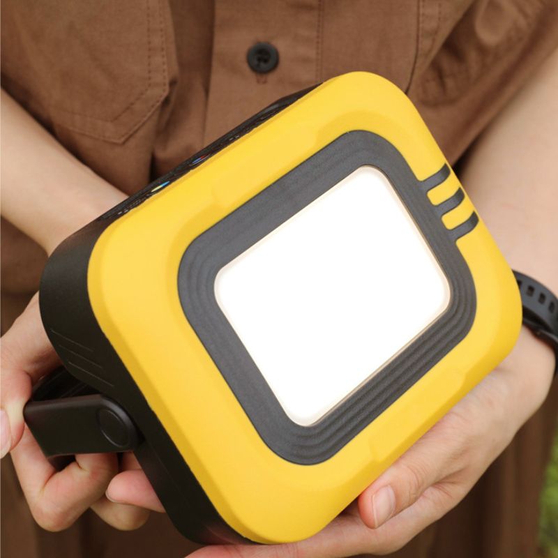 Person holding a yellow and black portable light