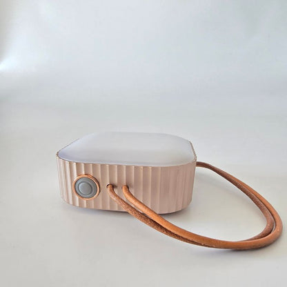Small electronic device with a leather strap on a white background
