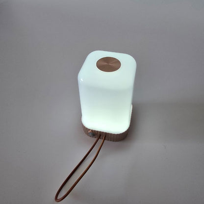 Glowing white square-shaped lamp with brown accents on a gray background