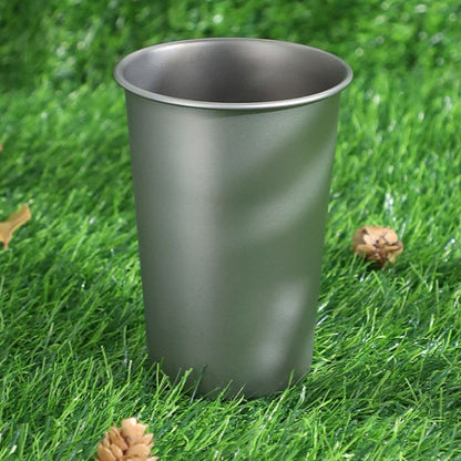 Gray metal cup on a grassy background