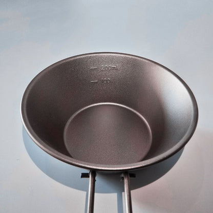 Empty metal pot with measurement markings on a light blue background