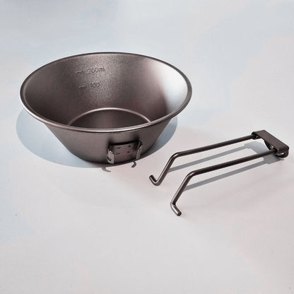 Black metal bowl with two hooks on a light gray background